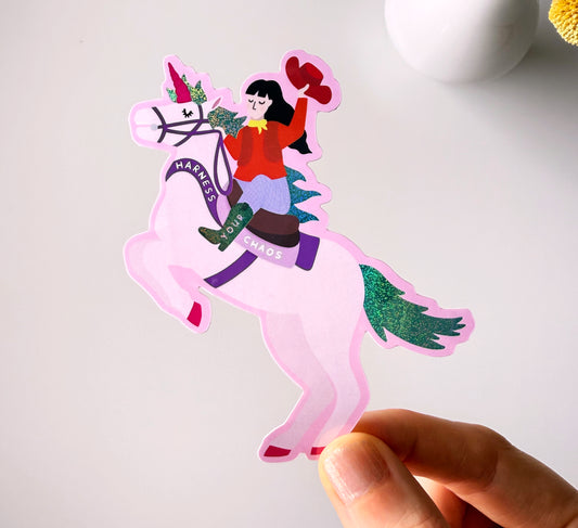Sparkly sticker of a cowgirl riding a unicorn that says 'Harness Your Chaos' - and ride it into town. Self-love, ADHD. Neurodivergent, Neurosparkly, self-acceptance, healing, power, strong woman, gift for strong women, empowering, gift for friends.